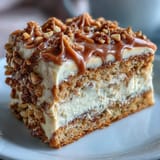 A close-up of Decadent Baked Biscoff Cake reveals a tender vanilla crumb swirled with spiced cookies and silky Lotus spread frosting.