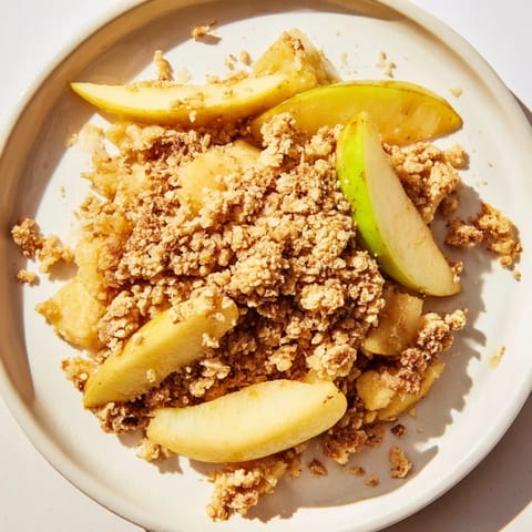 Golden, bubbly apple crumble, a warm dessert with a crisp, buttery oat topping.