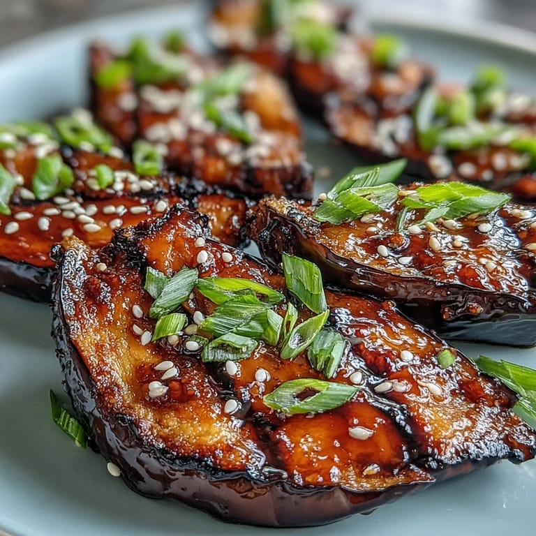 Freshly broiled miso glazed eggplant with a sticky caramelized glaze, sliced and served alongside fluffy steamed white rice.  
